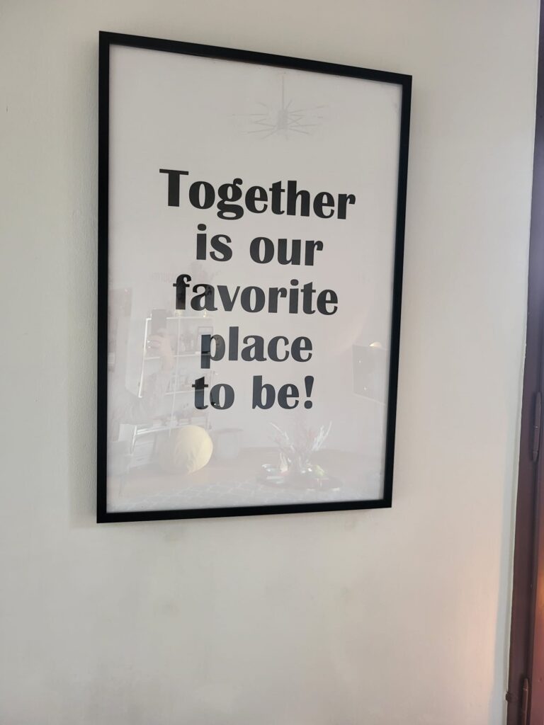 Ein Bilderrahmen mit einem großen Textdruck „Together is our favorite place to be!“