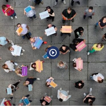 Das von oben aufgenommene Foto zeigt viele Mitarbeitende auf dem Hof am Rathaus, viele von Ihnen halten große Schilder in verschiedenen Farben mit der Aufschrift "Verwaltung mit Haltung".
