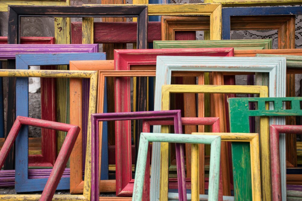 Das Foto zeigt eine Sammlung bunter Bilderrahmen aus Holz
