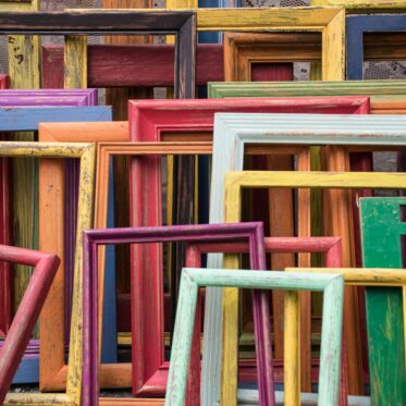 Das Foto zeigt eine Sammlung bunter Bilderrahmen aus Holz